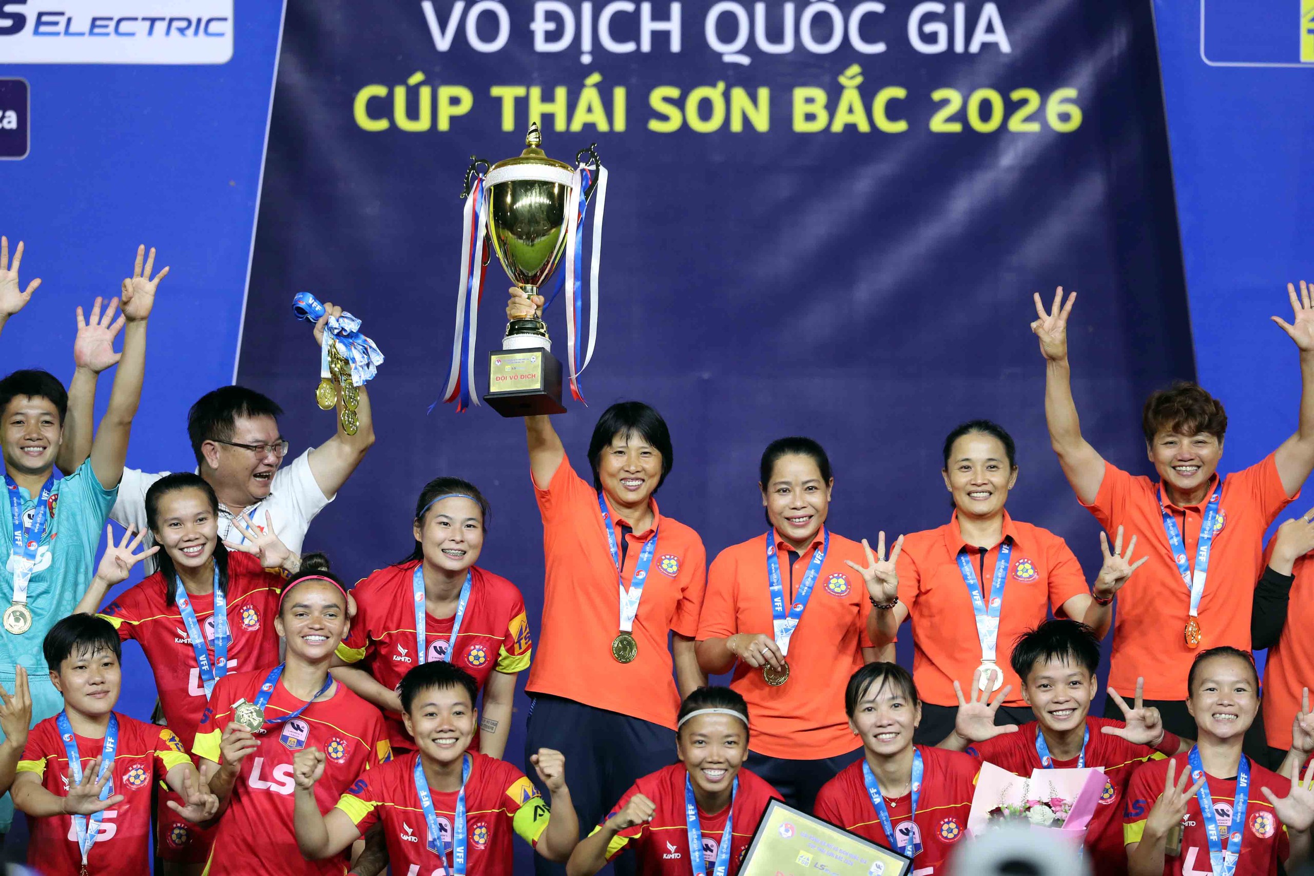 HLV Đoàn Thị Kim Chi giơ cúp vô địch ăn mừng cùng CLB TP.HCM I - Ảnh: N.K.